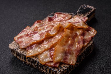 Kızarmış domuz pastırması, jambon, jambon veya jambon dilimleri. Tasarımın için arka plan olarak kızarmış pastırma dilimleri.