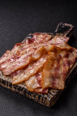 Kızarmış domuz pastırması, jambon, jambon veya jambon dilimleri. Tasarımın için arka plan olarak kızarmış pastırma dilimleri.