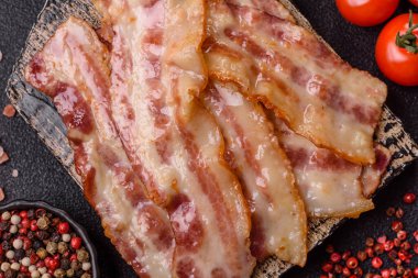 Kızarmış domuz pastırması, jambon, jambon veya jambon dilimleri. Tasarımın için arka plan olarak kızarmış pastırma dilimleri.
