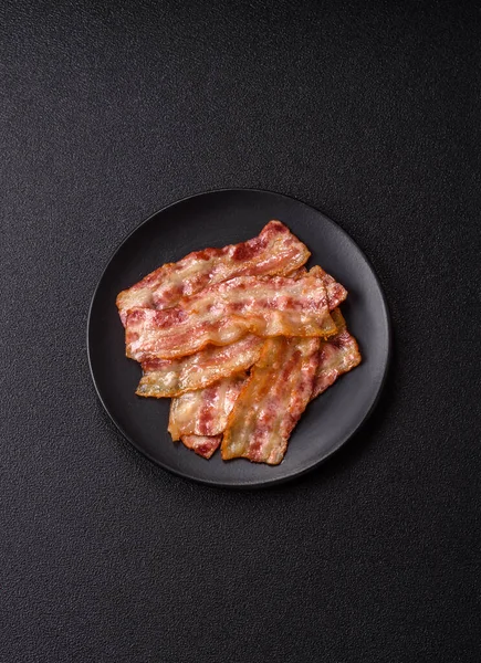 Kızarmış domuz pastırması, jambon, jambon veya jambon dilimleri. Tasarımın için arka plan olarak kızarmış pastırma dilimleri.