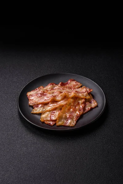 Kızarmış domuz pastırması, jambon, jambon veya jambon dilimleri. Tasarımın için arka plan olarak kızarmış pastırma dilimleri.