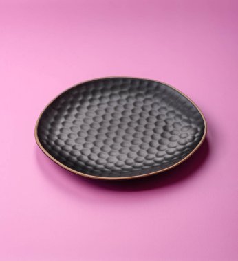 Mutfak malzemesi olarak pembe arka planda boş bir seramik tabak. Tasarımınız için yiyecek arka planı olarak boş bir tabak