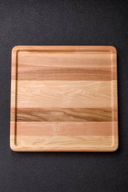 An empty wooden square tray or plate, kitchen utensils for food preparation. An empty wooden tray as a food background for your design