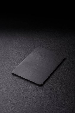 Siyah bir taş levha ya da tabak, boş bir mutfak aleti. Tasarımınız için yemek arkaplanı olarak siyah bir tahta.