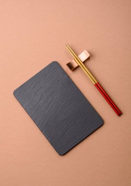 Siyah bir taş levha ya da tabak, boş bir mutfak aleti. Tasarımınız için yemek arkaplanı olarak siyah bir tahta.