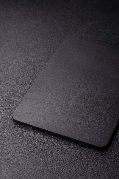 Siyah bir taş levha ya da tabak, boş bir mutfak aleti. Tasarımınız için yemek arkaplanı olarak siyah bir tahta.