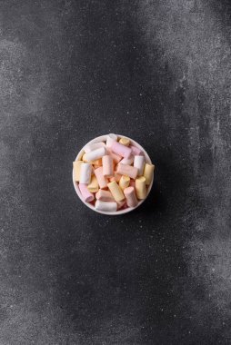 Beyaz, pembe ve pastel renkli mini marşmelovlar, renkli bir Noel tatlısı. Şekerlemeler, tasarımınız için bir gıda arka planıdır.