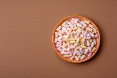 Beyaz, pembe ve pastel renkli mini marşmelovlar, renkli bir Noel tatlısı. Şekerlemeler, tasarımınız için bir gıda arka planıdır.