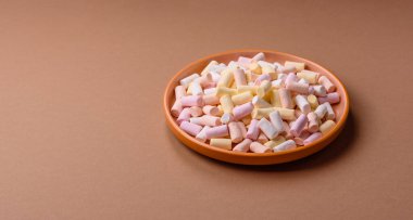 Beyaz, pembe ve pastel renkli mini marşmelovlar, renkli bir Noel tatlısı. Şekerlemeler, tasarımınız için bir gıda arka planıdır.