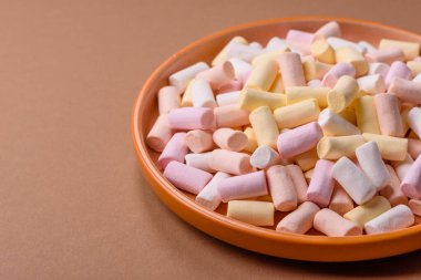 Beyaz, pembe ve pastel renkli mini marşmelovlar, renkli bir Noel tatlısı. Şekerlemeler, tasarımınız için bir gıda arka planıdır.