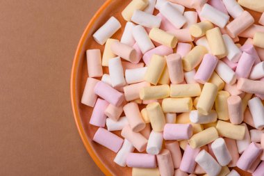 Beyaz, pembe ve pastel renkli mini marşmelovlar, renkli bir Noel tatlısı. Şekerlemeler, tasarımınız için bir gıda arka planıdır.