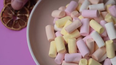 Beyaz, pembe ve pastel renkli mini marşmelovlar, renkli bir Noel tatlısı. Şekerlemeler, tasarımınız için bir gıda arka planıdır.