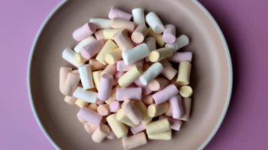 Beyaz, pembe ve pastel renkli mini marşmelovlar, renkli bir Noel tatlısı. Şekerlemeler, tasarımınız için bir gıda arka planıdır.