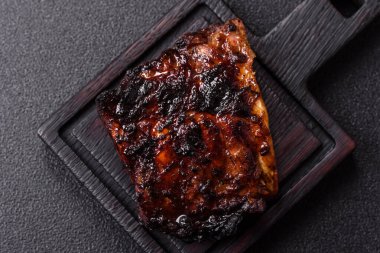 Grilled or barbecued pork or beef ribs, meat with red sauce, ready for the dinner table. Grilled ribs as a food background for your design
