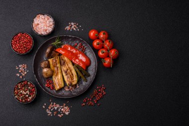 Vegetables such as corn, bell peppers, zucchini, and mushrooms grilled or barbecued, along with salt and spices for the dinner table. Grilled vegetables as a food background for your design