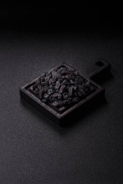 Sweet, dry black or blue raisins made from grapes are a healthy and nutritious food. Black raisins as a food background for your design