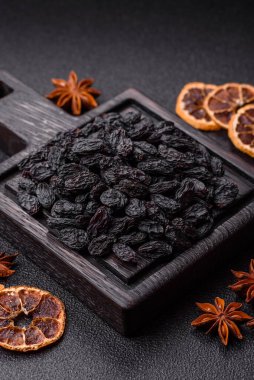 Sweet, dry black or blue raisins made from grapes are a healthy and nutritious food. Black raisins as a food background for your design