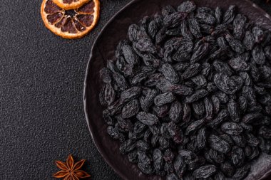 Üzümlerden yapılan tatlı, kuru siyah ya da mavi kuru üzümler sağlıklı ve besleyicidir. Tasarımınız için gıda arka planı olarak siyah kuru üzümler