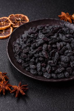 Üzümlerden yapılan tatlı, kuru siyah ya da mavi kuru üzümler sağlıklı ve besleyicidir. Tasarımınız için gıda arka planı olarak siyah kuru üzümler