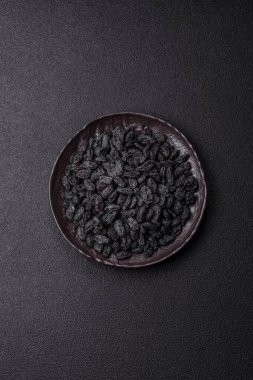 Üzümlerden yapılan tatlı, kuru siyah ya da mavi kuru üzümler sağlıklı ve besleyicidir. Tasarımınız için gıda arka planı olarak siyah kuru üzümler