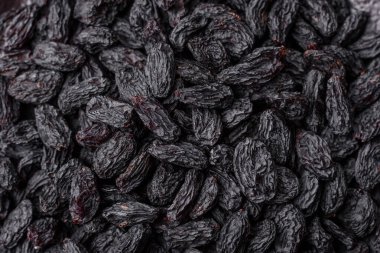 Üzümlerden yapılan tatlı, kuru siyah ya da mavi kuru üzümler sağlıklı ve besleyicidir. Tasarımınız için gıda arka planı olarak siyah kuru üzümler