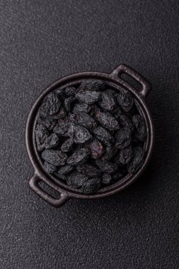 Üzümlerden yapılan tatlı, kuru siyah ya da mavi kuru üzümler sağlıklı ve besleyicidir. Tasarımınız için gıda arka planı olarak siyah kuru üzümler