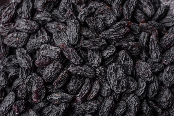 Üzümlerden yapılan tatlı, kuru siyah ya da mavi kuru üzümler sağlıklı ve besleyicidir. Tasarımınız için gıda arka planı olarak siyah kuru üzümler