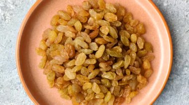 Üzümlerden yapılan tatlı, kuru, altın ya da sarı kuru üzüm sağlıklı, besleyici bir yemektir. Tasarımınız için gıda arka planı olarak altın kuru üzümler