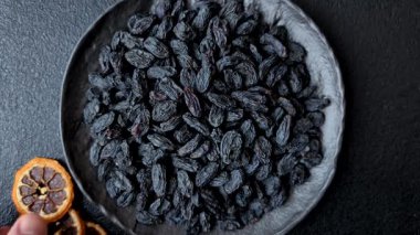 Üzümlerden yapılan tatlı, kuru siyah ya da mavi kuru üzümler sağlıklı ve besleyicidir. Tasarımınız için gıda arka planı olarak siyah kuru üzümler