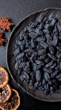 Üzümlerden yapılan tatlı, kuru siyah ya da mavi kuru üzümler sağlıklı ve besleyicidir. Tasarımınız için gıda arka planı olarak siyah kuru üzümler