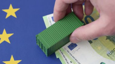 Mal ihracatı ve lojistik için kavramsal bir zemin olarak AB bayrağında bulunan kargo konteynerleri. Tasarımınız için arka plan olarak AB bayrağında bulunan kargo konteynerleri