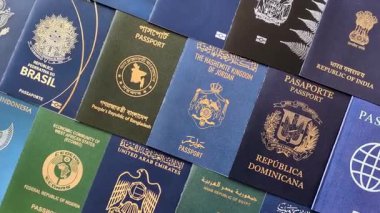 Farklı ülkelerin vatandaşlarının pasaportları, çeşitli ülkelerin pasaportlarından oluşan arka plan.