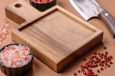 Yemek hazırlamak için bir bıçak, tuz ve baharatla boş tahta kesme tahtası. Tasarımınız için yiyecek arka planı olarak boş bir tahta kesme tahtası