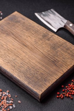 Yemek hazırlamak için bir bıçak, tuz ve baharatla boş tahta kesme tahtası. Tasarımınız için yiyecek arka planı olarak boş bir tahta kesme tahtası