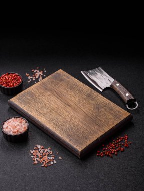 Yemek hazırlamak için bir bıçak, tuz ve baharatla boş tahta kesme tahtası. Tasarımınız için yiyecek arka planı olarak boş bir tahta kesme tahtası