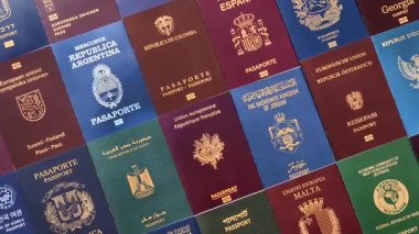 Farklı ülkelerin vatandaşlarının pasaportları, çeşitli ülkelerin pasaportlarından oluşan arka plan.