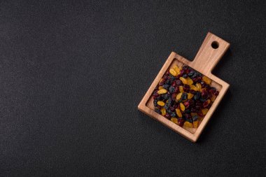 Kurutulmuş yaban mersini, sarı ve siyah tatlı üzümler granola ve kahvaltı malzemesi olarak kullanılıyor. Kuru üzümler ve kızılcıklar tasarımınız için gıda arka planı olarak kullanılıyor.