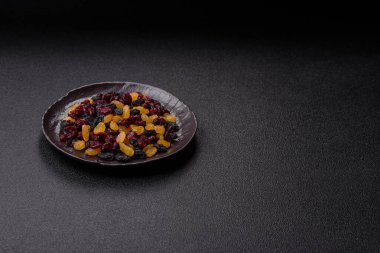 Kurutulmuş yaban mersini, sarı ve siyah tatlı üzümler granola ve kahvaltı malzemesi olarak kullanılıyor. Kuru üzümler ve kızılcıklar tasarımınız için gıda arka planı olarak kullanılıyor.