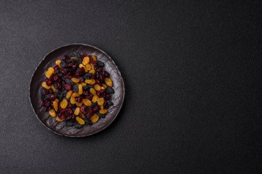 Kurutulmuş yaban mersini, sarı ve siyah tatlı üzümler granola ve kahvaltı malzemesi olarak kullanılıyor. Kuru üzümler ve kızılcıklar tasarımınız için gıda arka planı olarak kullanılıyor.