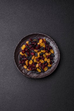 Kurutulmuş yaban mersini, sarı ve siyah tatlı üzümler granola ve kahvaltı malzemesi olarak kullanılıyor. Kuru üzümler ve kızılcıklar tasarımınız için gıda arka planı olarak kullanılıyor.