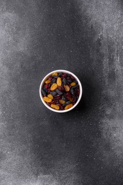 Kurutulmuş yaban mersini, sarı ve siyah tatlı üzümler granola ve kahvaltı malzemesi olarak kullanılıyor. Kuru üzümler ve kızılcıklar tasarımınız için gıda arka planı olarak kullanılıyor.