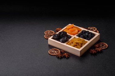 Sağlıklı bir kahvaltı için çeşitli kurutulmuş meyve, kayısı, kuru erik, kızılcık, kuru üzüm, incir ve hurma çeşitleri. Tasarımınız için gıda arka planı olarak kurutulmuş meyve karışımı