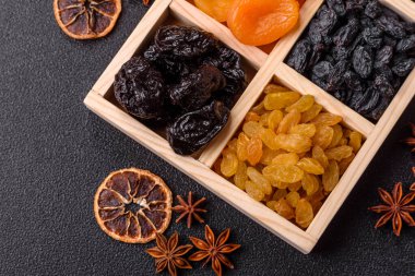 Sağlıklı bir kahvaltı için çeşitli kurutulmuş meyve, kayısı, kuru erik, kızılcık, kuru üzüm, incir ve hurma çeşitleri. Tasarımınız için gıda arka planı olarak kurutulmuş meyve karışımı