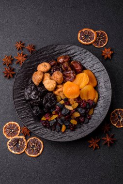 Sağlıklı bir kahvaltı için çeşitli kurutulmuş meyve, kayısı, kuru erik, kızılcık, kuru üzüm, incir ve hurma çeşitleri. Tasarımınız için gıda arka planı olarak kurutulmuş meyve karışımı