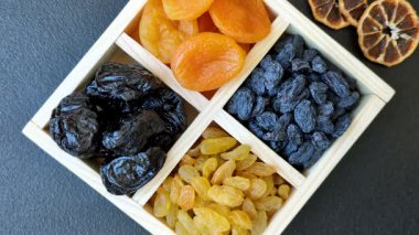 Sağlıklı bir kahvaltı için çeşitli kurutulmuş meyve, kayısı, kuru erik, kızılcık, kuru üzüm, incir ve hurma çeşitleri. Kurutulmuş meyve karışımı.