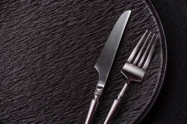 Boş bir seramik tabak, bıçak ve çatal yemek masası olarak kullanılıyor. Tasarımınız için arka plan olarak boş bir tabak