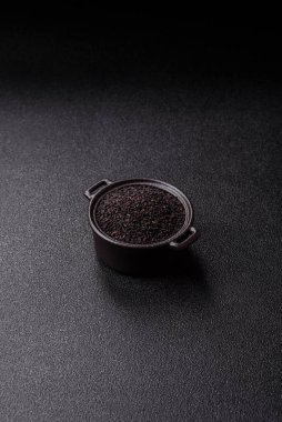 Bir kasede siyah susam tohumu, yağ ve sağlıklı yemek için bir malzeme. Tasarımınız için yiyecek arkaplanı olarak siyah susam