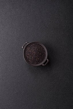 Bir kasede siyah susam tohumu, yağ ve sağlıklı yemek için bir malzeme. Tasarımınız için yiyecek arkaplanı olarak siyah susam