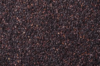 Bir kasede siyah susam tohumu, yağ ve sağlıklı yemek için bir malzeme. Tasarımınız için yiyecek arkaplanı olarak siyah susam