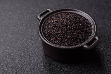 Bir kasede siyah susam tohumu, yağ ve sağlıklı yemek için bir malzeme. Tasarımınız için yiyecek arkaplanı olarak siyah susam